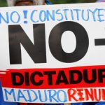 An opposition supporter holds a placard during a protest against Venezuela’s President Nicolas Maduro’s government in Caracas